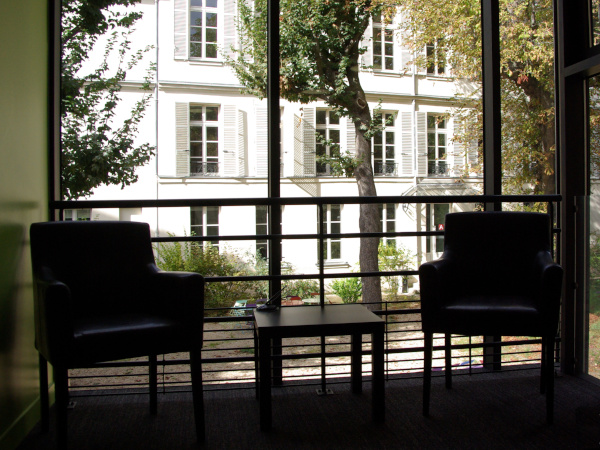 salle de lecture, deux fauteuils dos au jardin et au bâtiment de la faculté